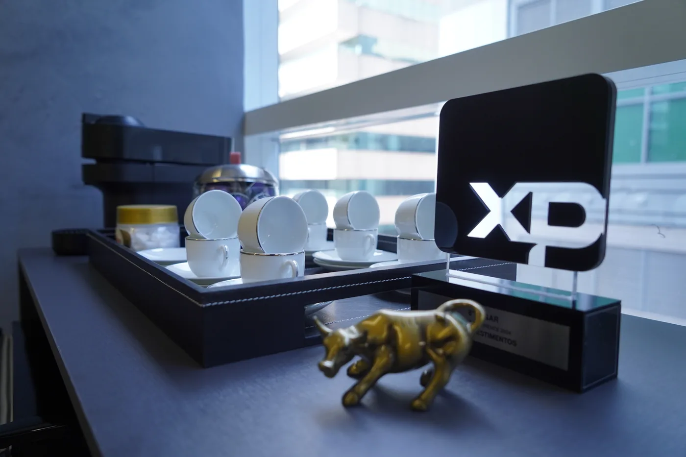 Escritório da DOM Investimentos, com o troféu XP e a taça do touro